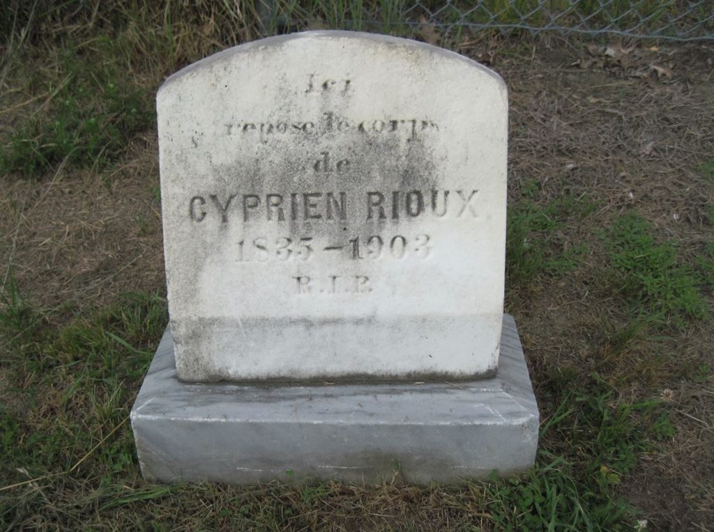 Grave stone that reads: "Ici repose le corps de Cyprien Rioux 1835-1903 R.I.P."